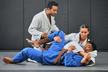 Foto auf Acrylglas Antireflex Mma, martial arts and exercise with a coach, teacher or instructor instructing students during practice, training or sparring in a gym or dojo. Fighting and self defense class for health and fitness © Delcio Fernandes/peopleimages.com