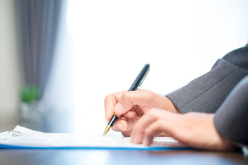 Workplace closeup person professional businesswoman sitting at desk hold pen signing or signature...