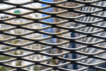 Mesh for a fence made of metal structures in a city park.