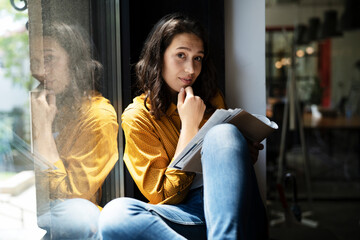 Young businesswoman drinking coffee in her office. Woman enjoy in coffee break.