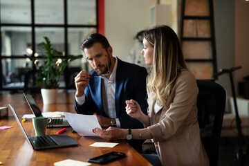 Colleagues in office. Businesswoman and businessman discussing work in office..