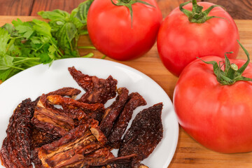 Sun-dried tomatoes against the fresh tomatoes close-up