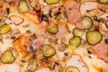 Pizza with different ham, mushrooms and pickled cucumbers, fragment, background