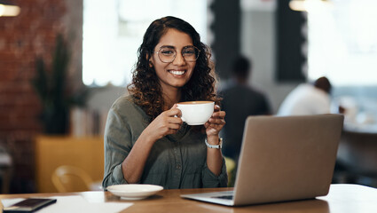 Creative entrepreneur with a laptop drinking coffee, browsing internet and searching startup...