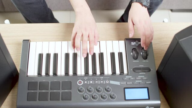 Sitting person playing keyboard on the living room