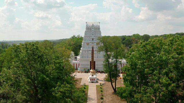 Aerial drone forward moving shot of a traditional south Indian hindu temple situated in the rural countryside.
