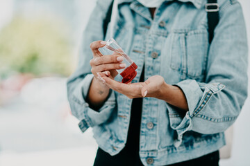 Closeup of woman using hand sanitizer while in public or travelling with copy space. Female practicing good health and hygiene, sticking to corona regulations. Lady suffering from OCD or germ phobia