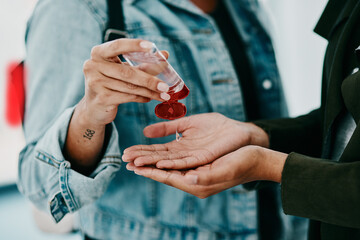 Closeup of woman cleaning themselves with hand sanitizer, medical and healthy during the pandemic. Health, hygiene and safety adults clean their hands to stop the spread of covid in office space.