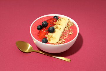 Smoothie with different ingredients and spoon on pink background