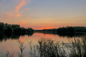 Naklejka na ściany i meble Summer sunset over calm lake