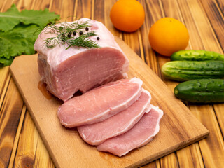 Tasty raw veal or beef meat on wooden cutting board. Preparing for frying.