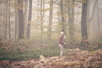 Jeune fille qui se prom&egrave;ne dans la for&ecirc;t en automne