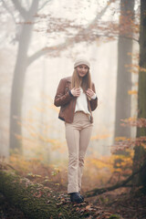 Jeune fille qui se prom&egrave;ne dans la for&ecirc;t en automne