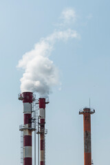 Air pollution by smoke coming out of two factory chimneys.