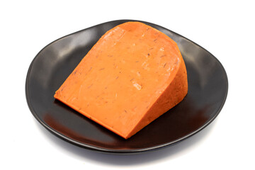 Red gouda cheese. Guoda cheese with sun-dried tomatoes and basil isolated on a white background. Dutch cheese. close up
