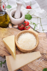 Grated Parmesan cheese on a wooden cutting board at domestic kitchen