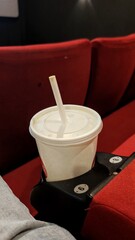 a glass of soda in the cinema, in place for the cup holder