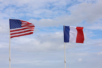 waving flags of the United States of America and France on a sky