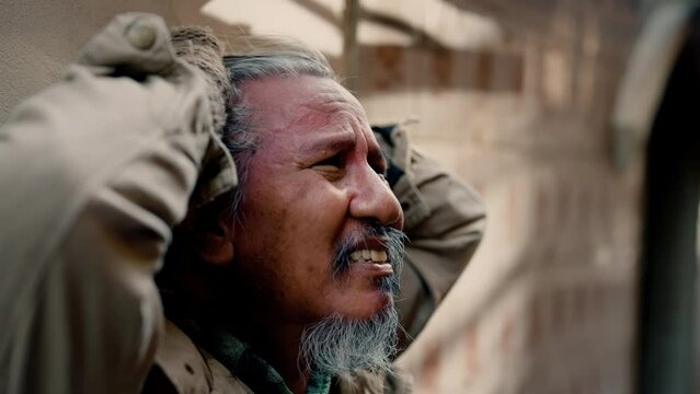 4k, Close Up The face of a dirty-dressed, long-haired, long-haired old man, who is homeless, is showing signs of serious stress because he has no food to eat and no work to sleep on the streets.
