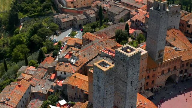 People On Top Of Medieval Towers In Piazza della Cisterna Sightseeing In Historic Centre Of San Gimignano, UNESCO Heritage Site In Tuscany, Italy. aerial drone orbit