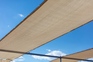 White fabric against the blue sky. Sun protection