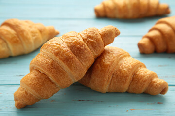 Freshly baked croissants on blue wooden background Warm Fresh Buttery Croissants and Rolls. French and American Croissants and Baked Pastries