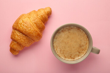 Croissant with cup of coffee on pink background. High quality photo