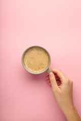 Obraz na płótnie Canvas Female hand hold coffee cup on pink background.