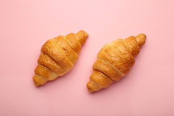 Freshly baked croissants on pink background. French and American Croissants and Baked Pastries