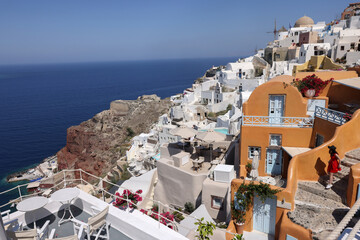 Fototapeta na wymiar Whitewashed houses with terraces and pools and a beautiful view in Oia on Santorini island, Greece