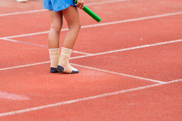 Fototapeta na wymiar A child athlete runs a race wearing only socks.