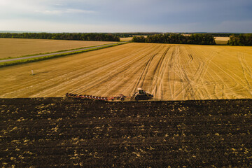 Fototapeta premium Tractor with plowing system prepares the agricultural land for planting crop
