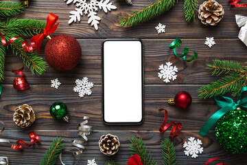 Digital phone mock up with rustic Christmas decorations for app presentation top view with empty space for you design. Christmas online shopping concept. Tablet with copy space on colored background