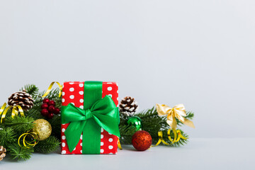 New Year Christmas mood, gift box, branches of a christmas tree, New Year decorations on a colored background