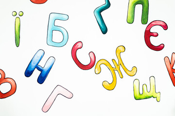Ukrainian alphabet painting on the white wall in the classroom. Multicolored letters drawing on white background