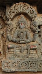 Fototapeta na wymiar Sculpture of Lord Vishnu Sitting in a Dhyan Position, Lakshminarshimha Temple, Javagal, Hassan, Karnataka, India. Hoysala Temple. 
