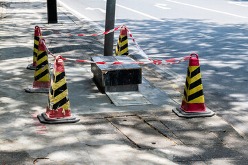 Sewer repair work with signal cones on footpath