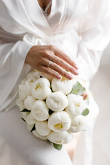Wedding bouquet in bride's hands with white peonies