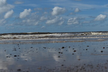 Dramatic cloudy sky over the sea with waves crashing onto the beach. Taken in Fleetwood Lancashire England. 