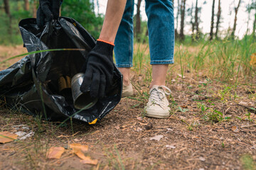 Plastic garbage in nature clean up volunteer hands picks up a plastic bottles in forest....