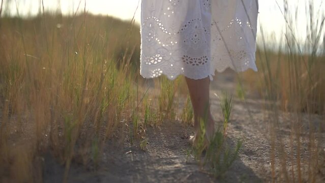Woman gently walking on the beach with some plants in slow motion