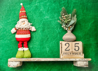 santa toy on a shelf, wooden calendar with 25 december date, christmas banner, copy space for promo or ad
