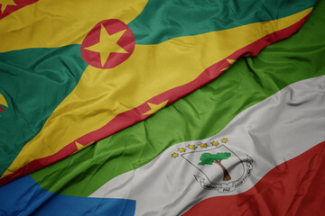 waving colorful flag of equatorial guinea and national flag of grenada.