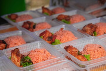Nasi Ayam Tomato in takeaway container for sale in a stall in Malaysia.