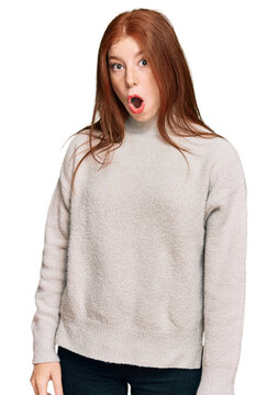 Young read head woman wearing casual winter sweater scared and amazed with open mouth for surprise, disbelief face