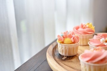 Cropped shot of cupcake on wooden tray on wooden table, food and sweet concept