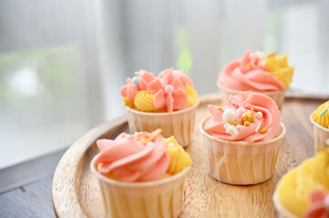 Cropped shot of homemade cupcake on wooden tray on wooden table