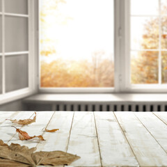 Desk of free space and autumn window background. 