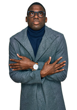 Young african american man wearing business clothes and glasses shaking and freezing for winter cold with sad and shock expression on face