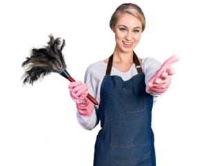 Beautiful young blonde woman wearing apron holding cleaning duster smiling friendly offering handshake as greeting and welcoming. successful business.